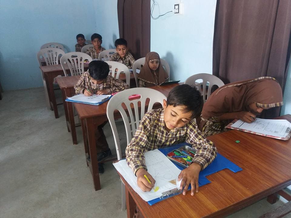 Students studying and drawing in classroom