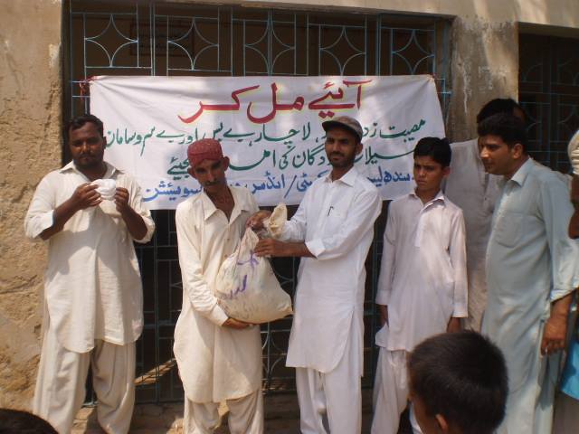 Relief supply distribution with Urdu banner