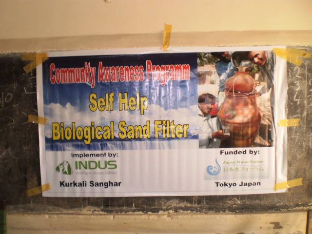 NFI distribution banner – Indus Welfare and IOM at Kurkali